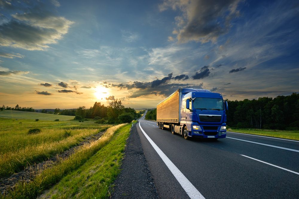Semi-remorque sur route au coucher du soleil